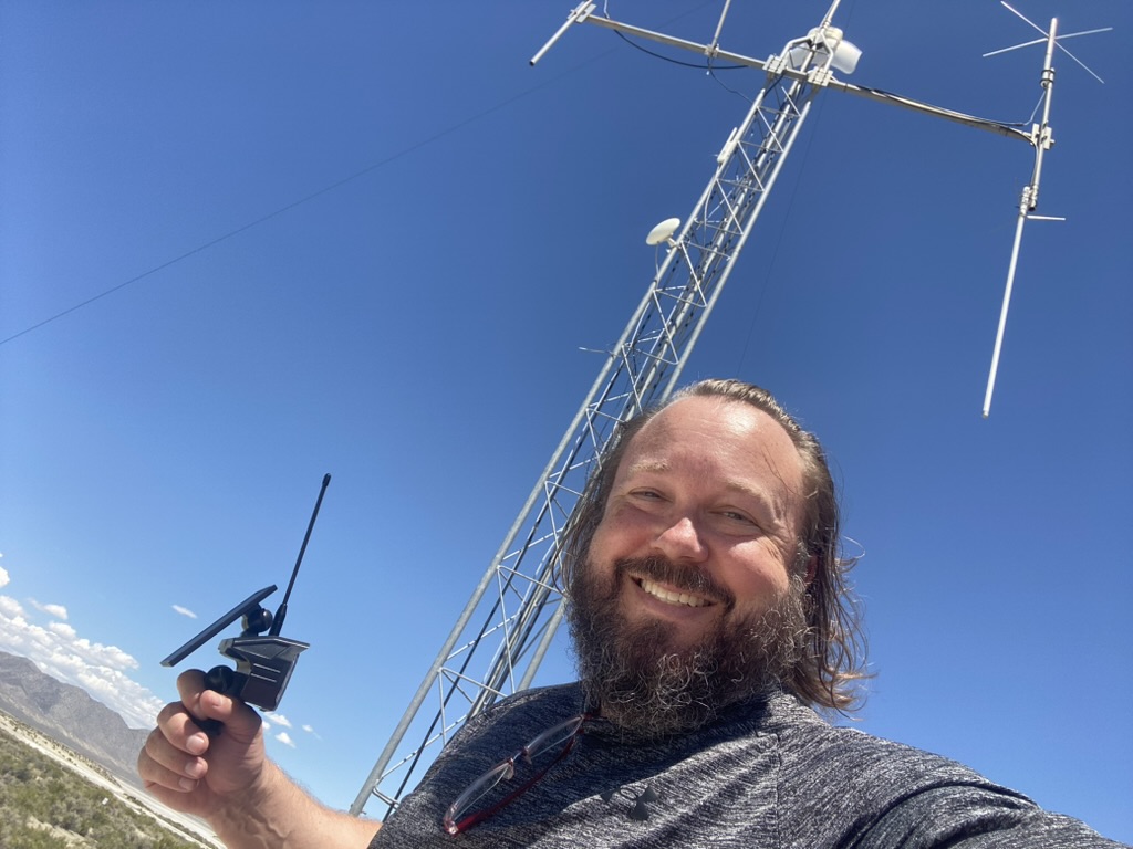 Ben Allfree with a solar mesh handheld at the ROG tower in Gerlach, desert mountains behind
