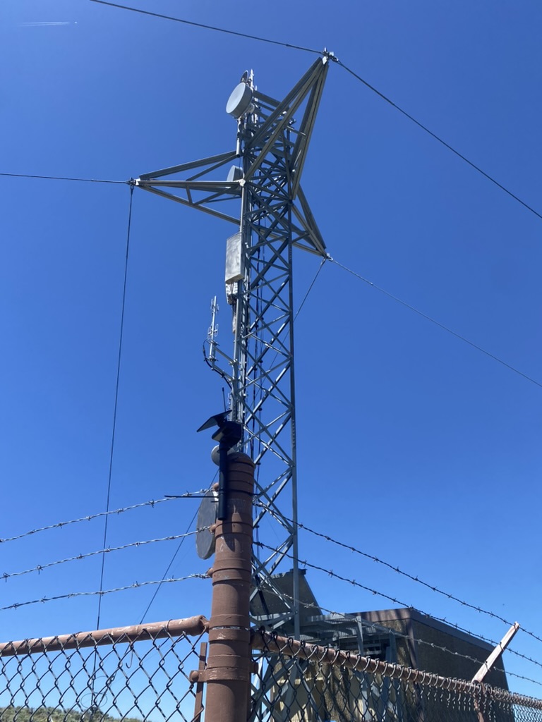 Solar mesh node on a fence post with the Sierra Electronics tower behind