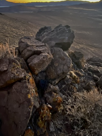 Ruslito in the rocks with the desert basin stretching out below Russell Peak