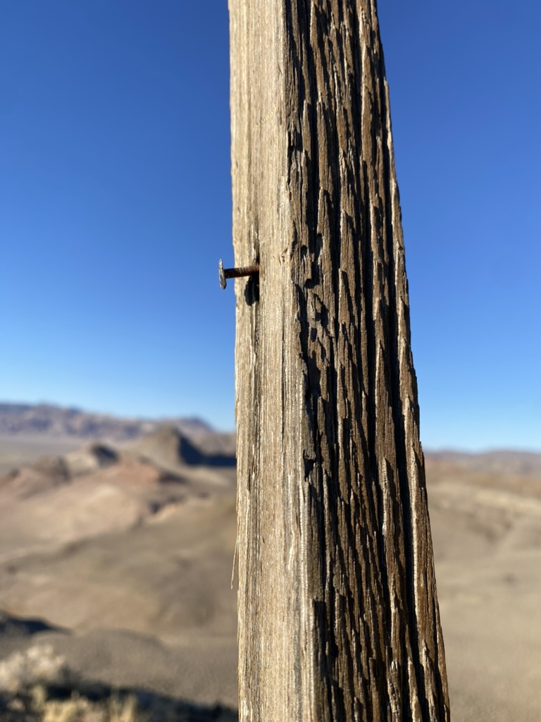 The original mount: one rusty nail driven into a weathered wooden post